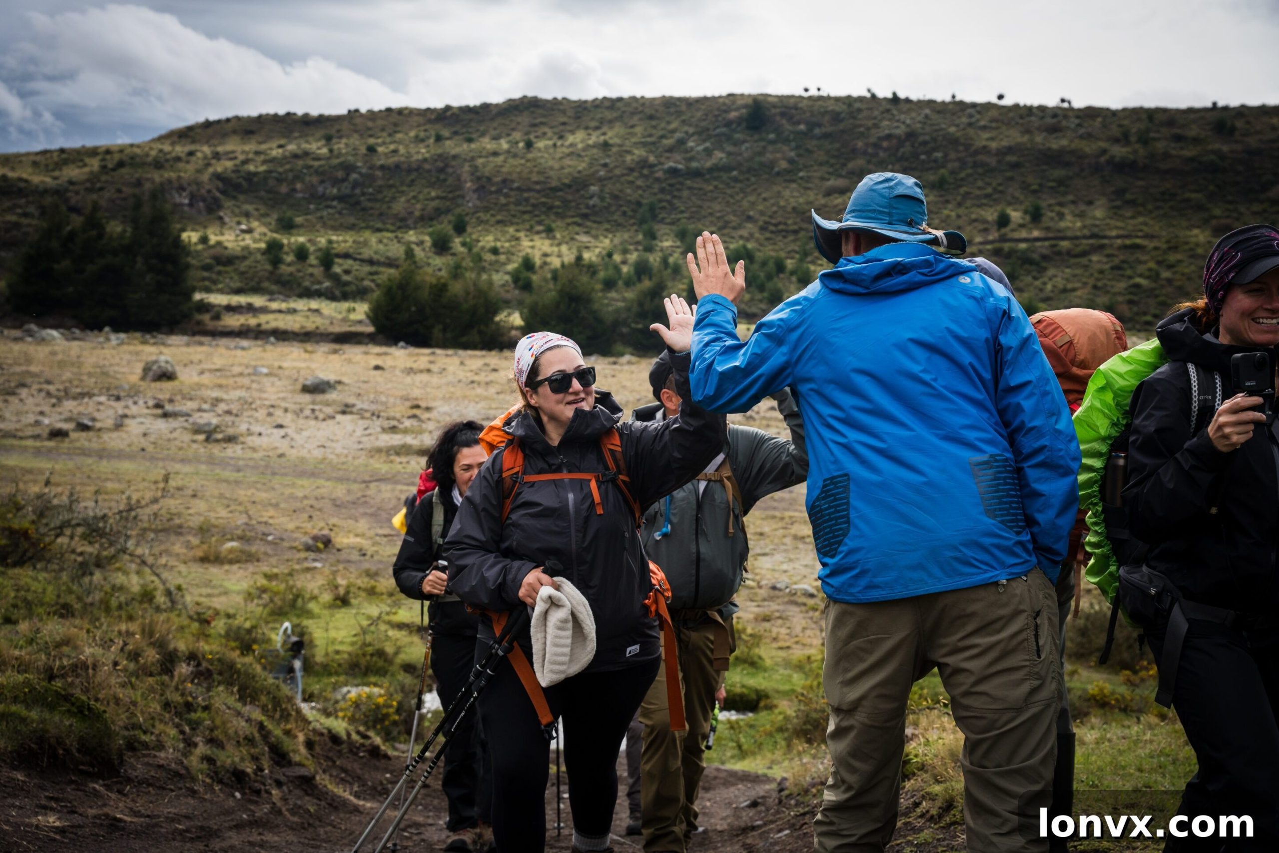 Royal LePage trekkers on a mountain trail in Ecuador, with a guide leading the way and breathtaking Andean scenery in the background.