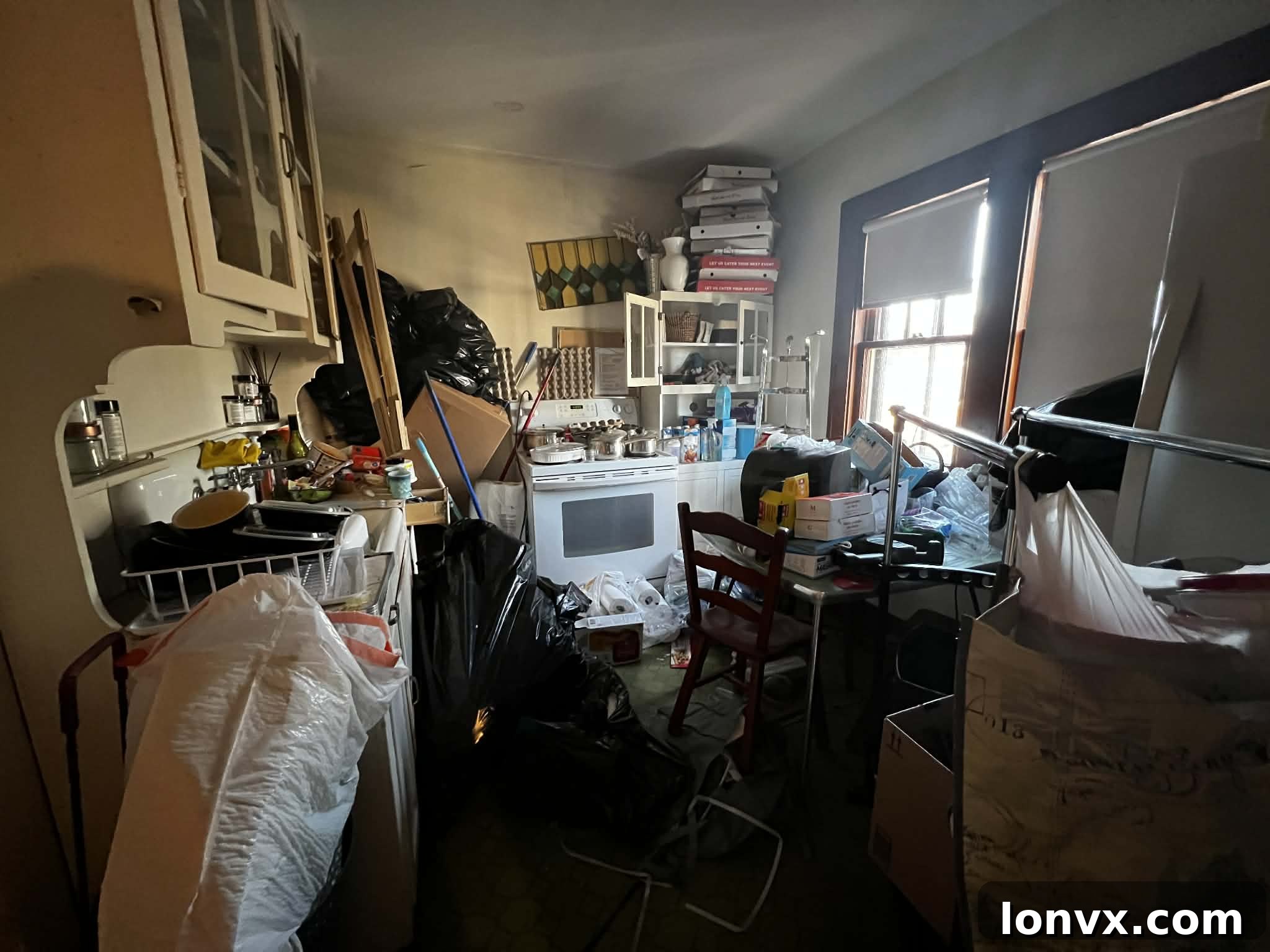 Before image of a hoarder house before Border City Living's renovation, showing significant clutter and disarray.